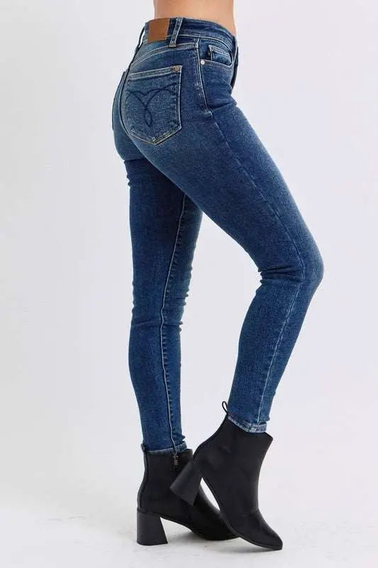Judy Blue mid-rise skinny jeans with thermal lining, blue denim, side view, worn with black ankle boots.