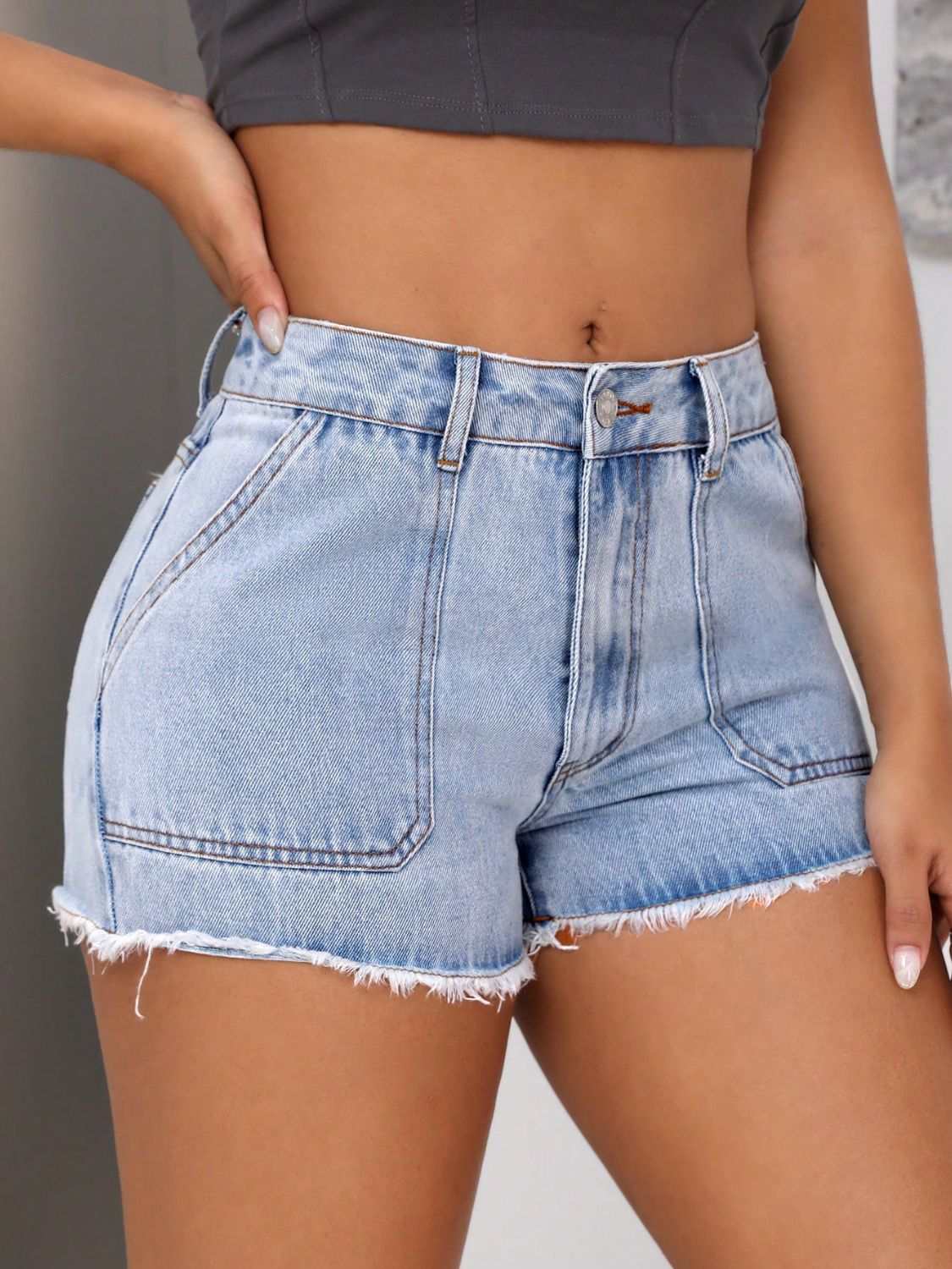 Raw hem pocketed denim shorts with button, no stretch, cotton-polyester blend.