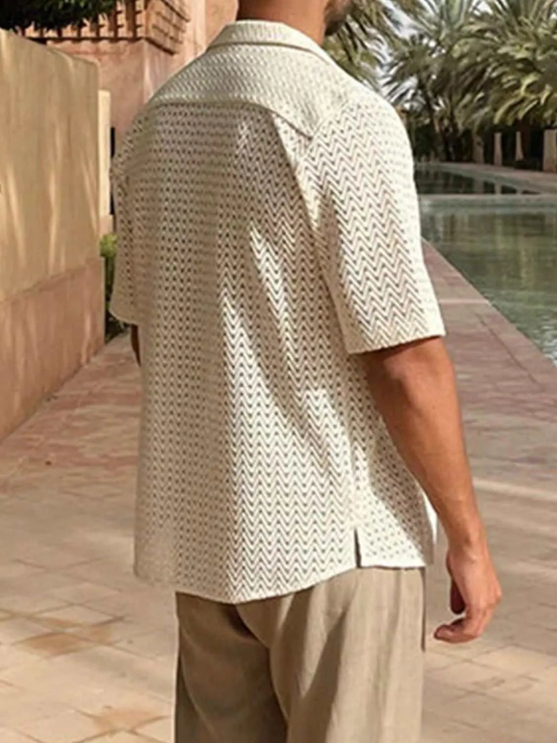 Men's plus size herringbone eyelet button-down knit shirt in light fabric with short sleeves, shown worn outdoors.