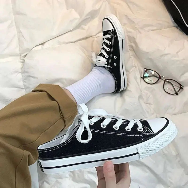 Round toe lace-up canvas sneakers with rubber sole in black.