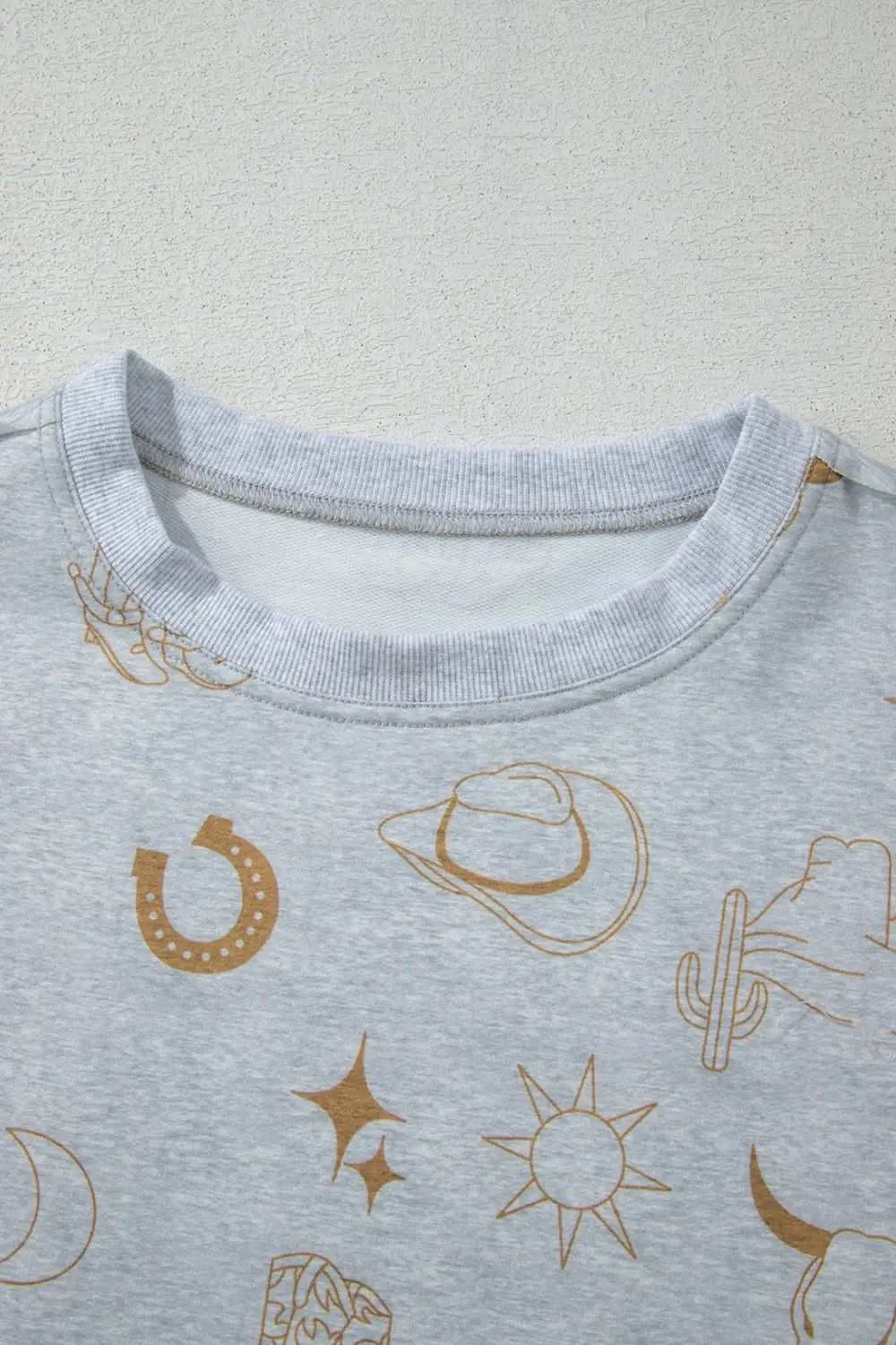 Printed T-shirt with cowboy-themed graphics and rounded neckline.