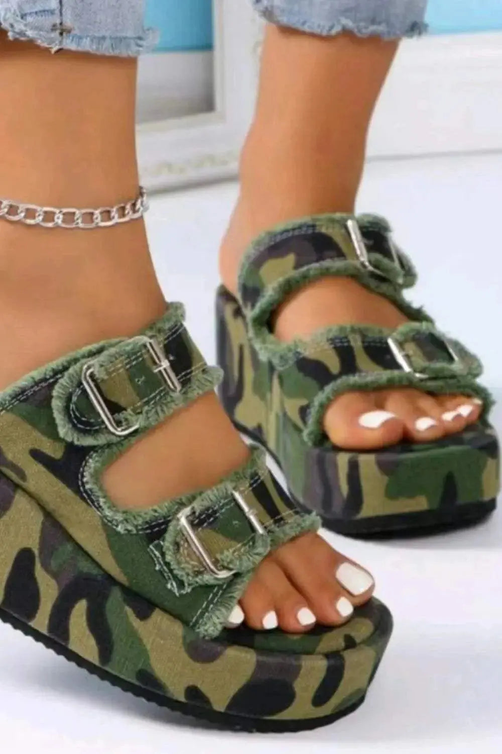 Raw hem wedge buckle sandals with camo pattern and mid heels.