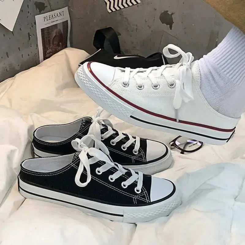 Round toe lace-up canvas sneakers in white and black, rubber soles.