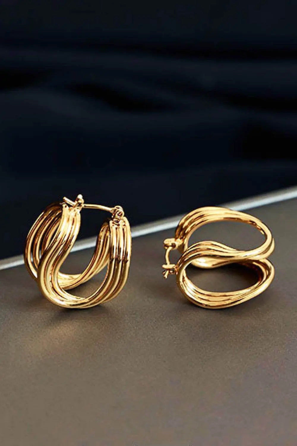 U-Shaped hoop earrings in brass, studio flat lay.