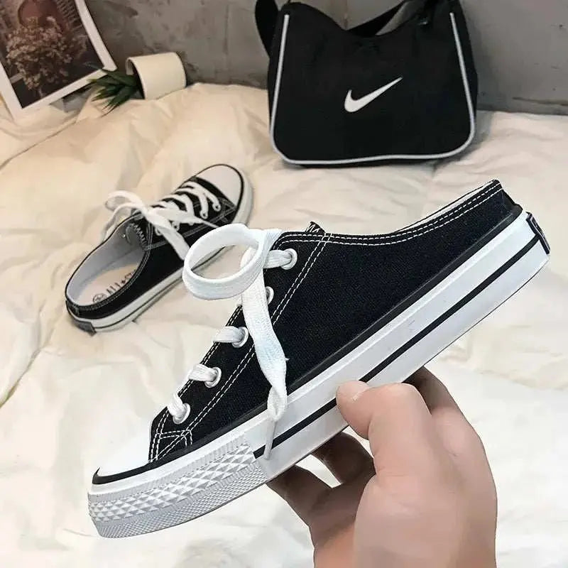 Round toe lace-up canvas sneakers with white laces, black upper, and rubber soles.