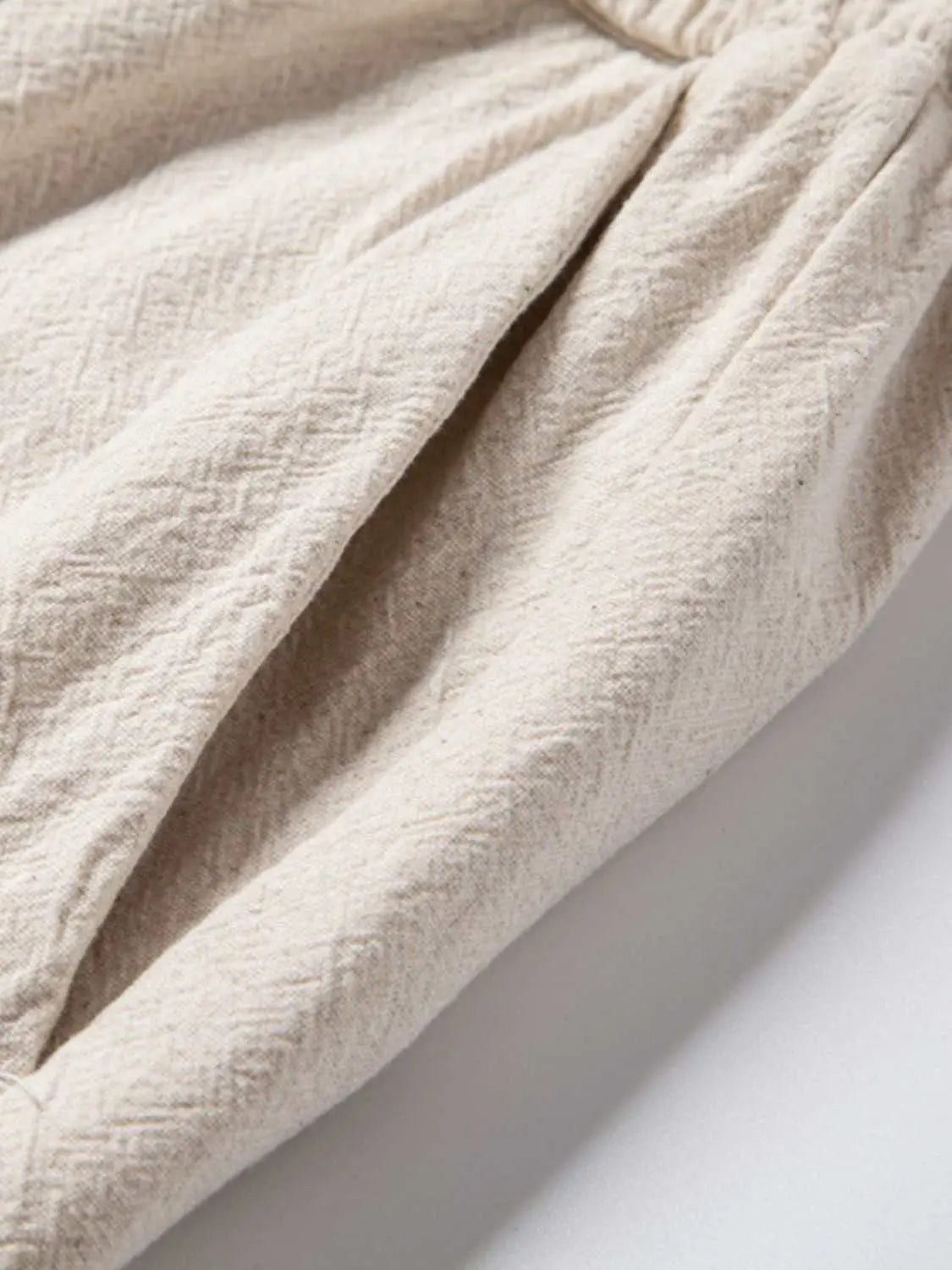 Men's drawstring pants with textured fabric detail.