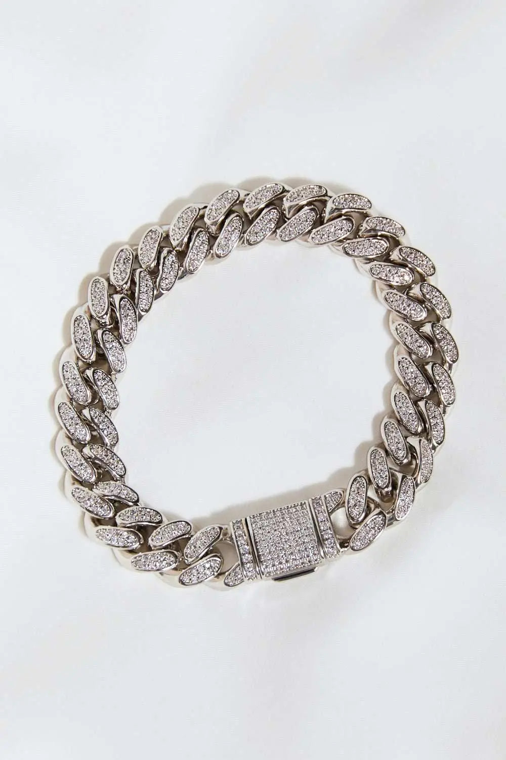 Curb chain bracelet in brass, studio flat lay style.