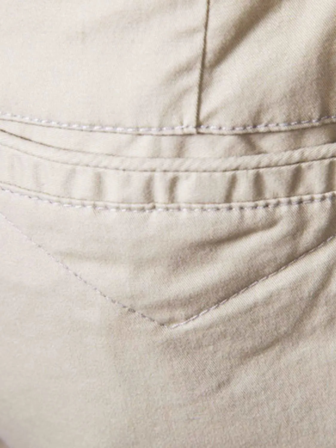 Men's elastic waist shorts with pockets, 100% cotton, close-up of beige pocket detail.