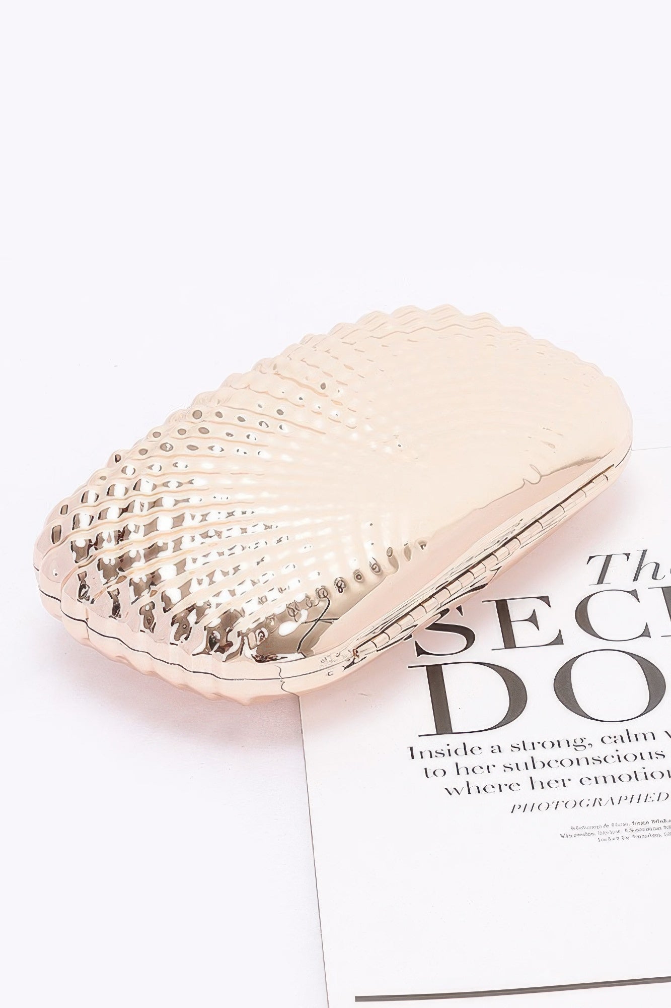 Side profile of the structured metal clutch for women with a polished finish