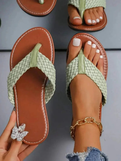 Braided toe post flats sandals in green with rubber and PU material, shown worn on feet.
