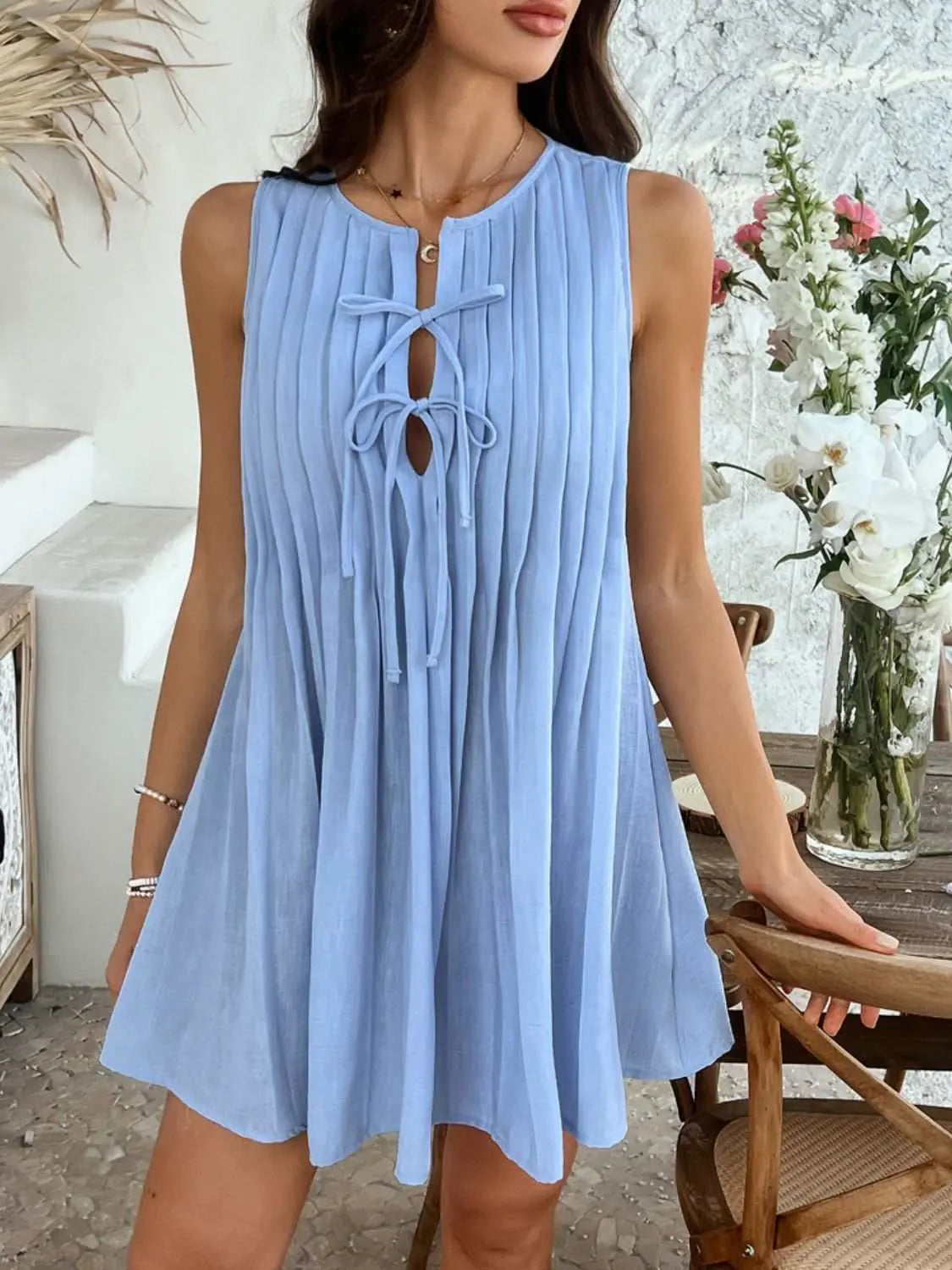 Devine Pleated Sleeveless Mini Dress in blue, featuring a tied pleat design.