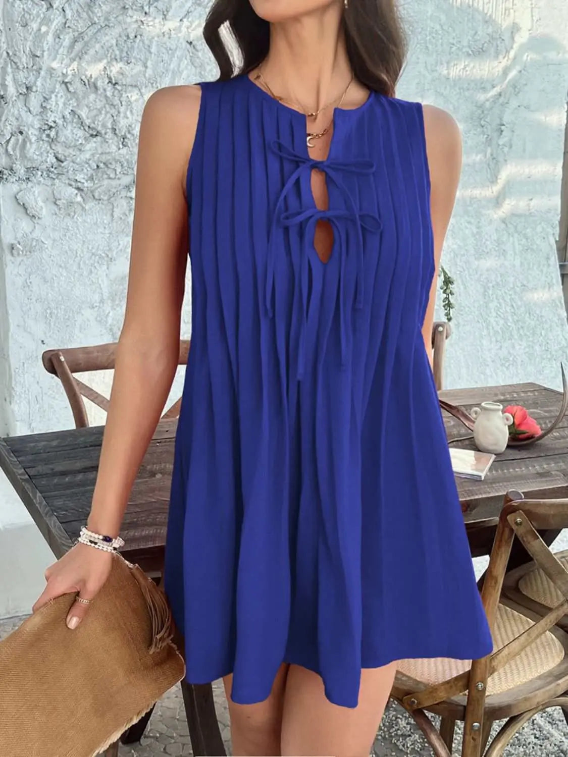 Devine Pleated Sleeveless Mini Dress in blue with tie detail, slightly stretchy polyester fabric.