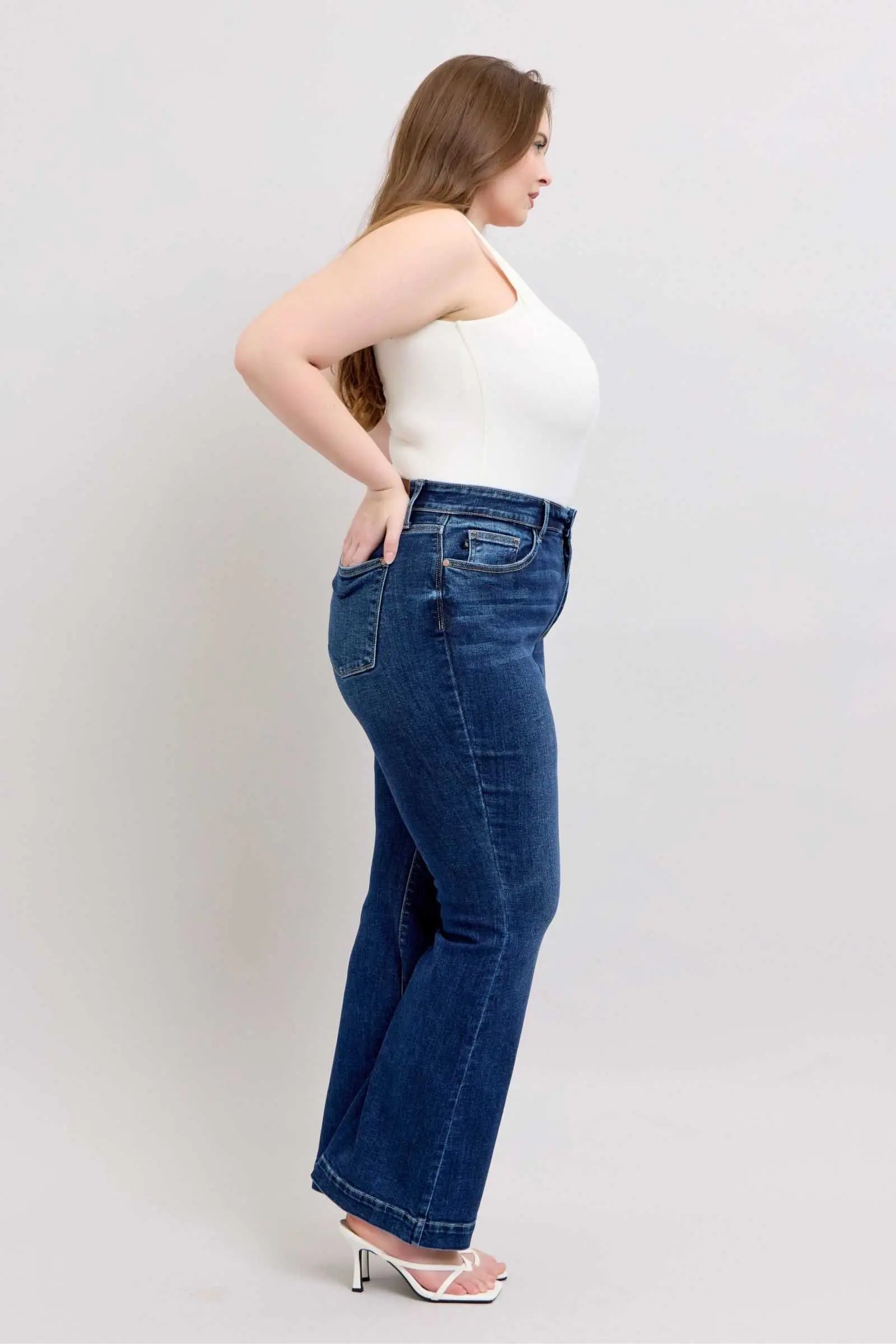 Judy Blue full-size high rise flare jeans with pockets, plus size model, side view.