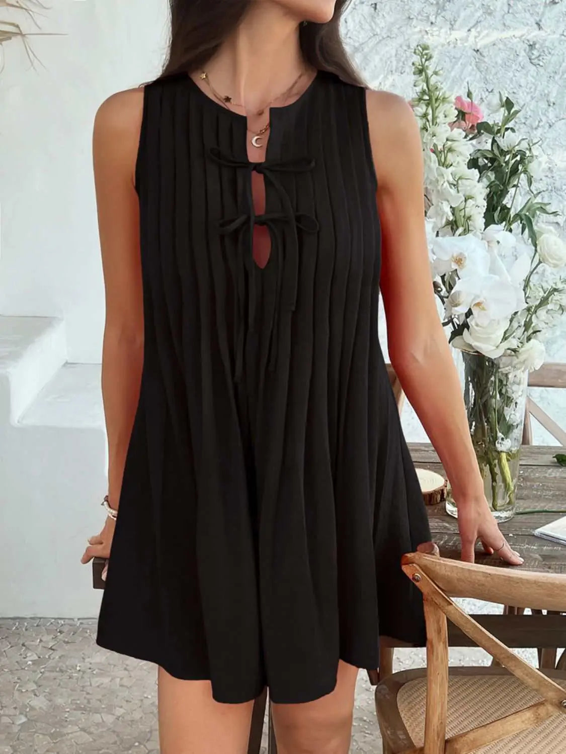 Devine Pleated Sleeveless Mini Dress in black, featuring a tied and pleated design.