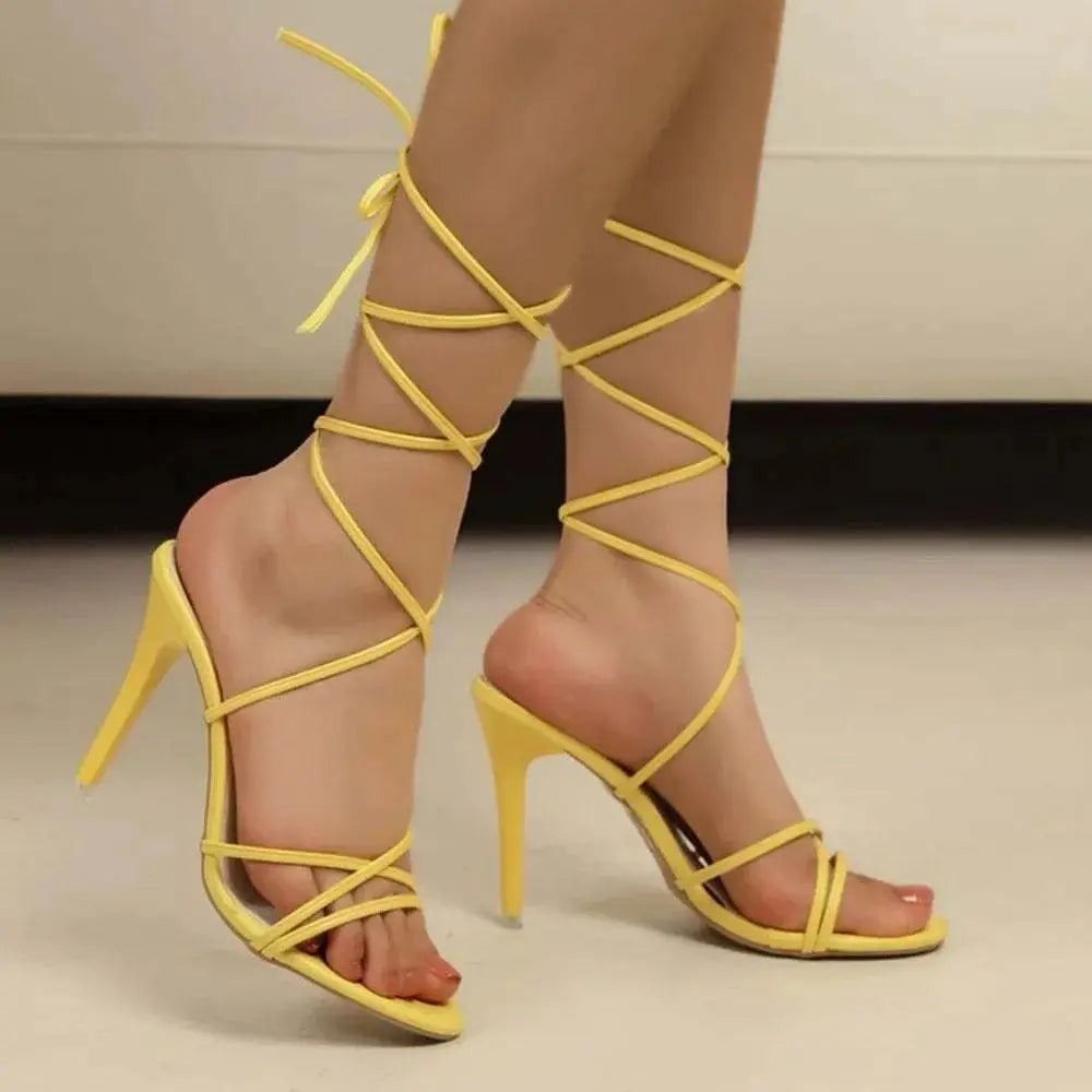 Cross strap stiletto sandals in yellow PU leather with high heels, featuring a sleek design for elegant footwear.