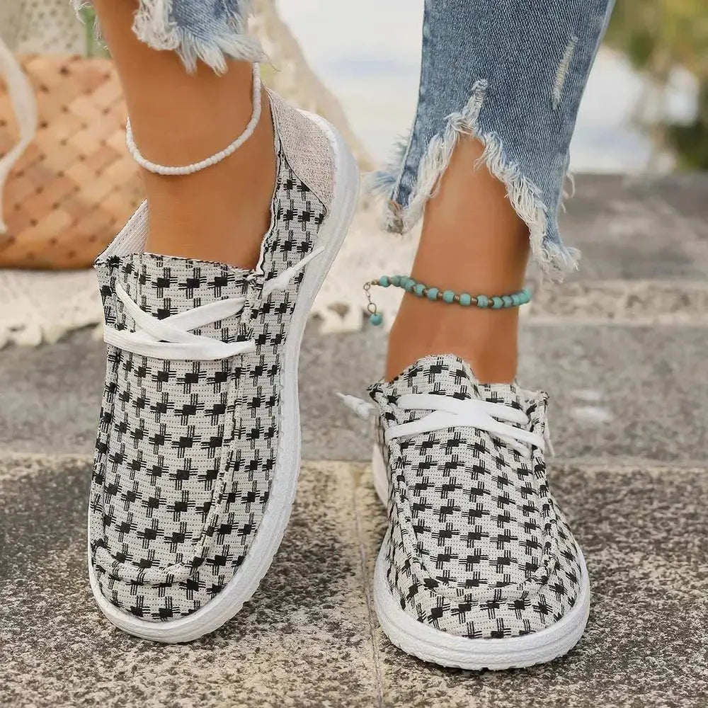 Plaid round toe canvas slip-ons with flat rubber soles.