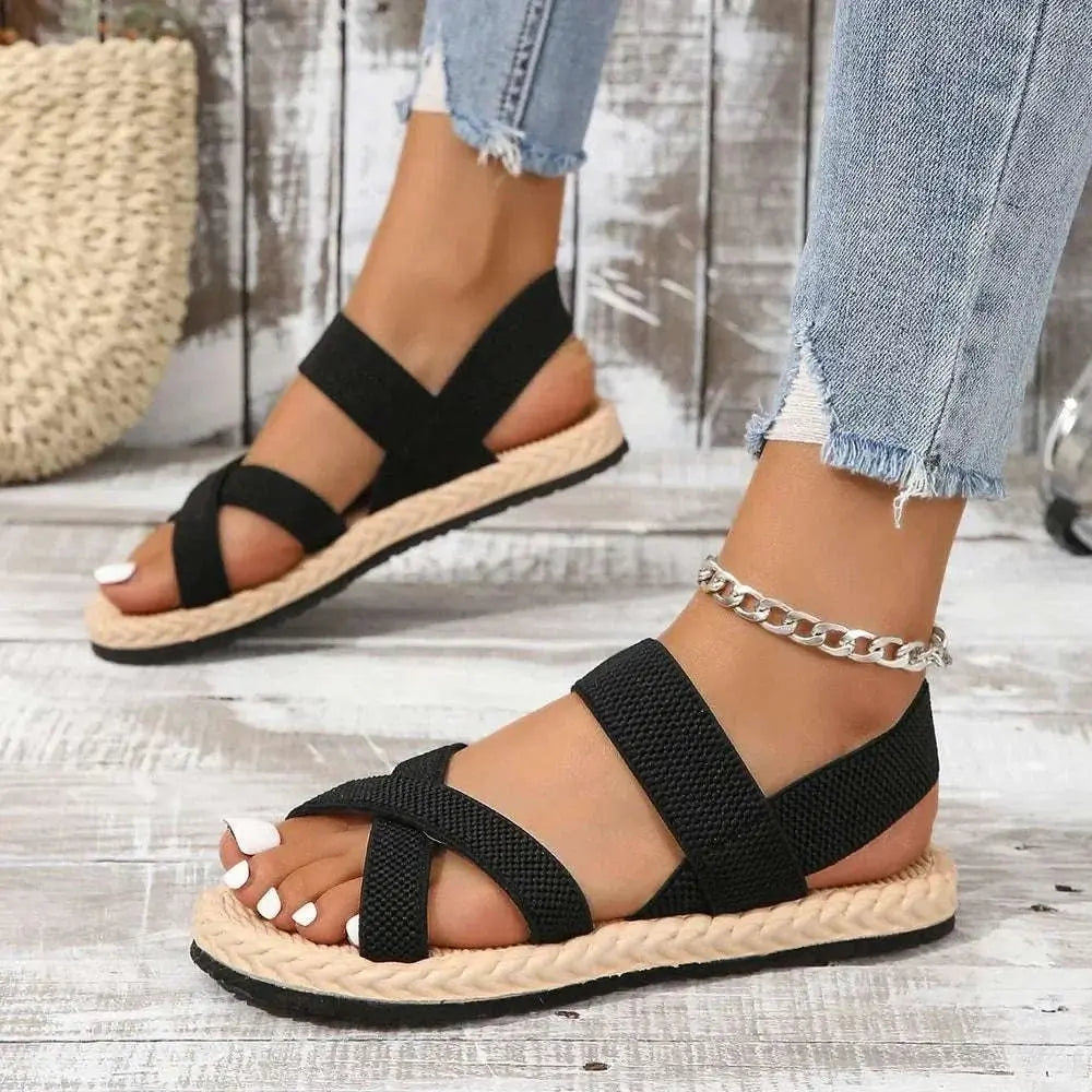 Crisscross Open Toe Flat Sandals with black straps and natural sole.