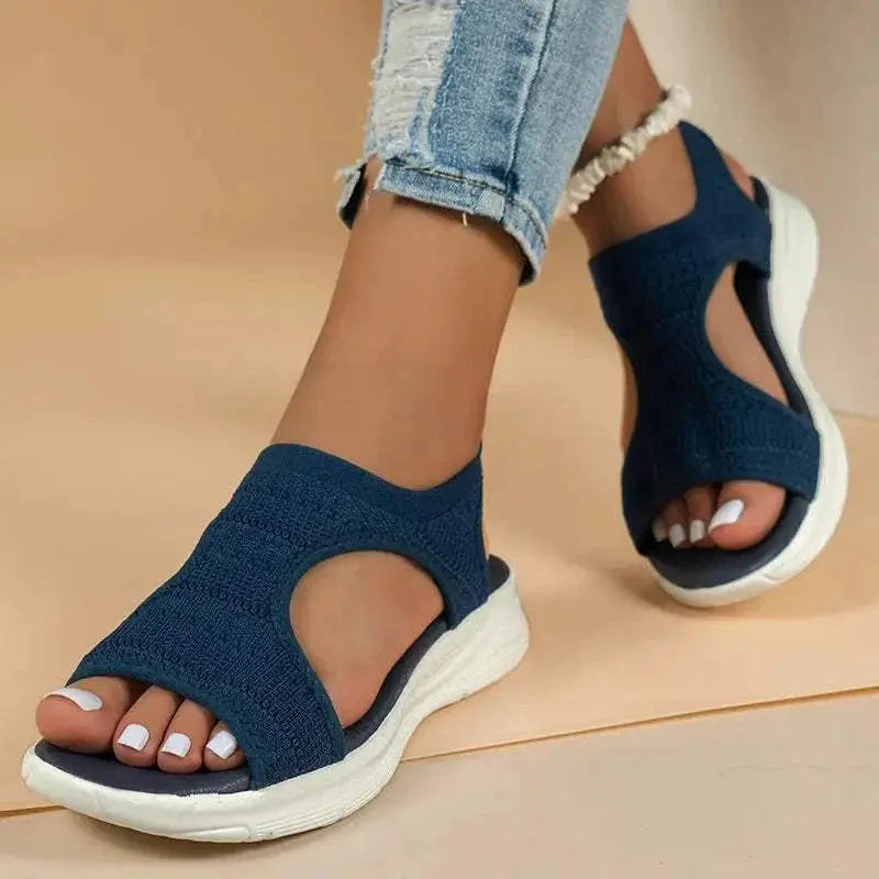 Peep toe solid color sandals in navy blue with a white sole, featuring a rubber and cloth material.