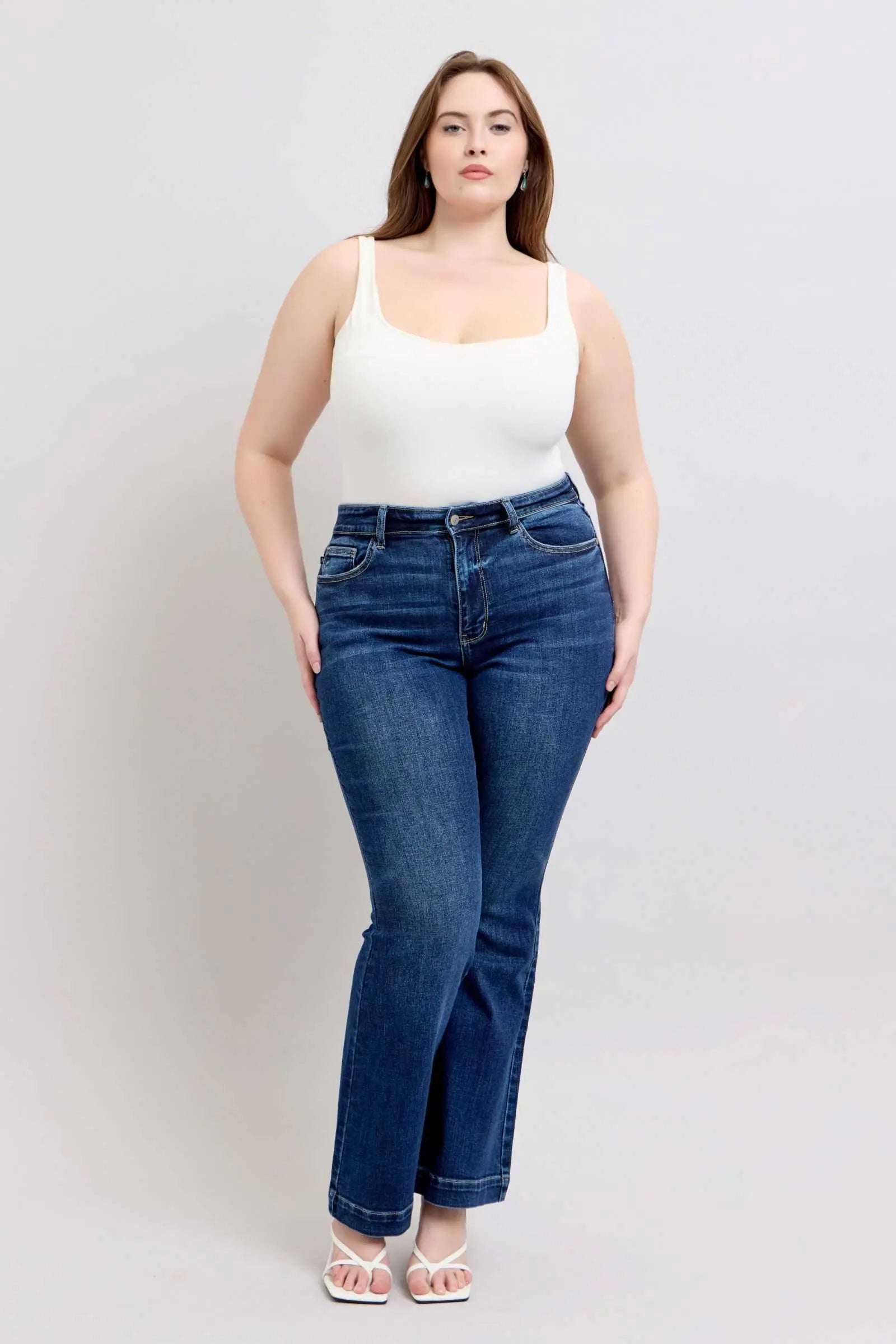 Plus size model wearing Judy Blue Full Size High Rise Flare Jeans with Pockets, showcasing trendy high-waisted silhouette and stylish flare leg design.