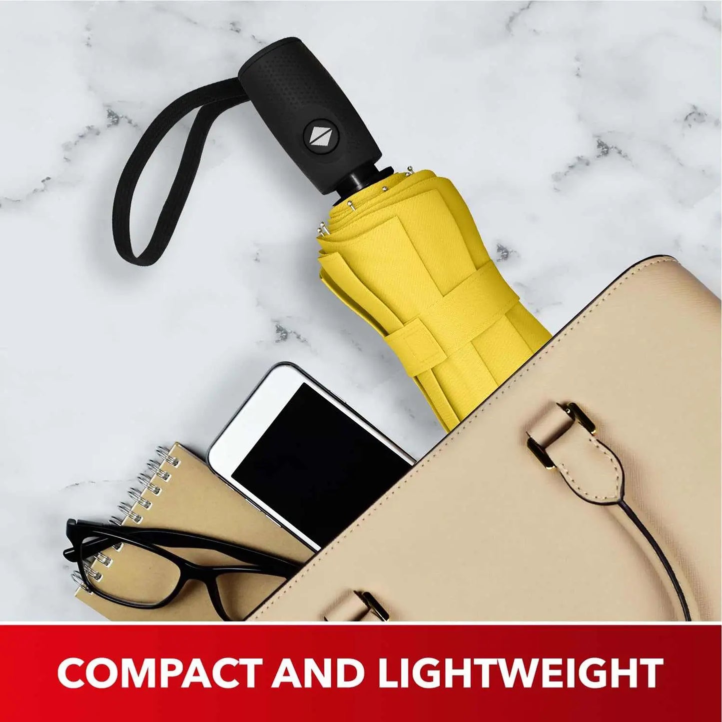 Compact and lightweight yellow Repel Umbrella Windproof in a beige bag alongside a notebook, glasses, and smartphone.