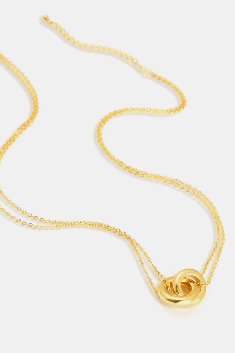 Elegant linked ring pendant chain necklace in brass with flat lay style.