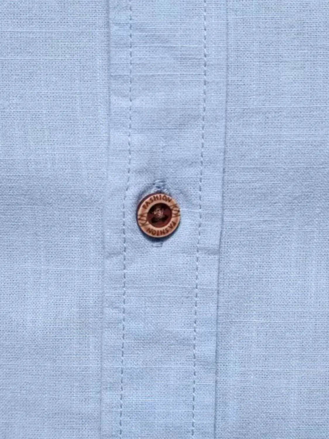 Men's full size button down embroidered shirt fabric and button detail.