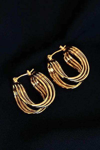 U-shaped brass hoop earrings in studio flat lay.