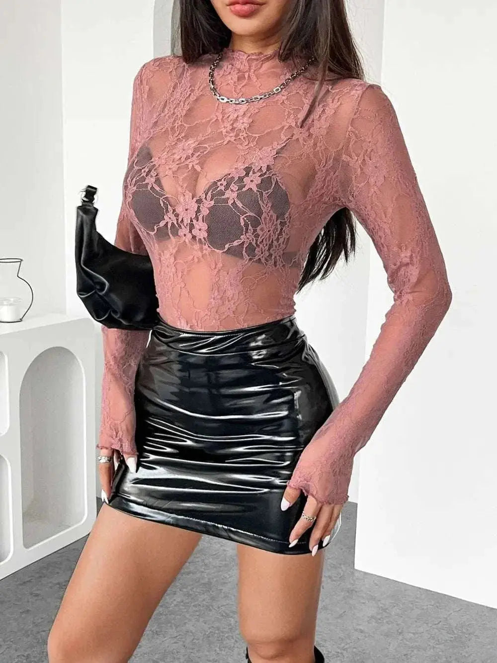 Mock neck long sleeve sheer lace top in pink with a slightly stretchy fit, paired with a black leather skirt.
