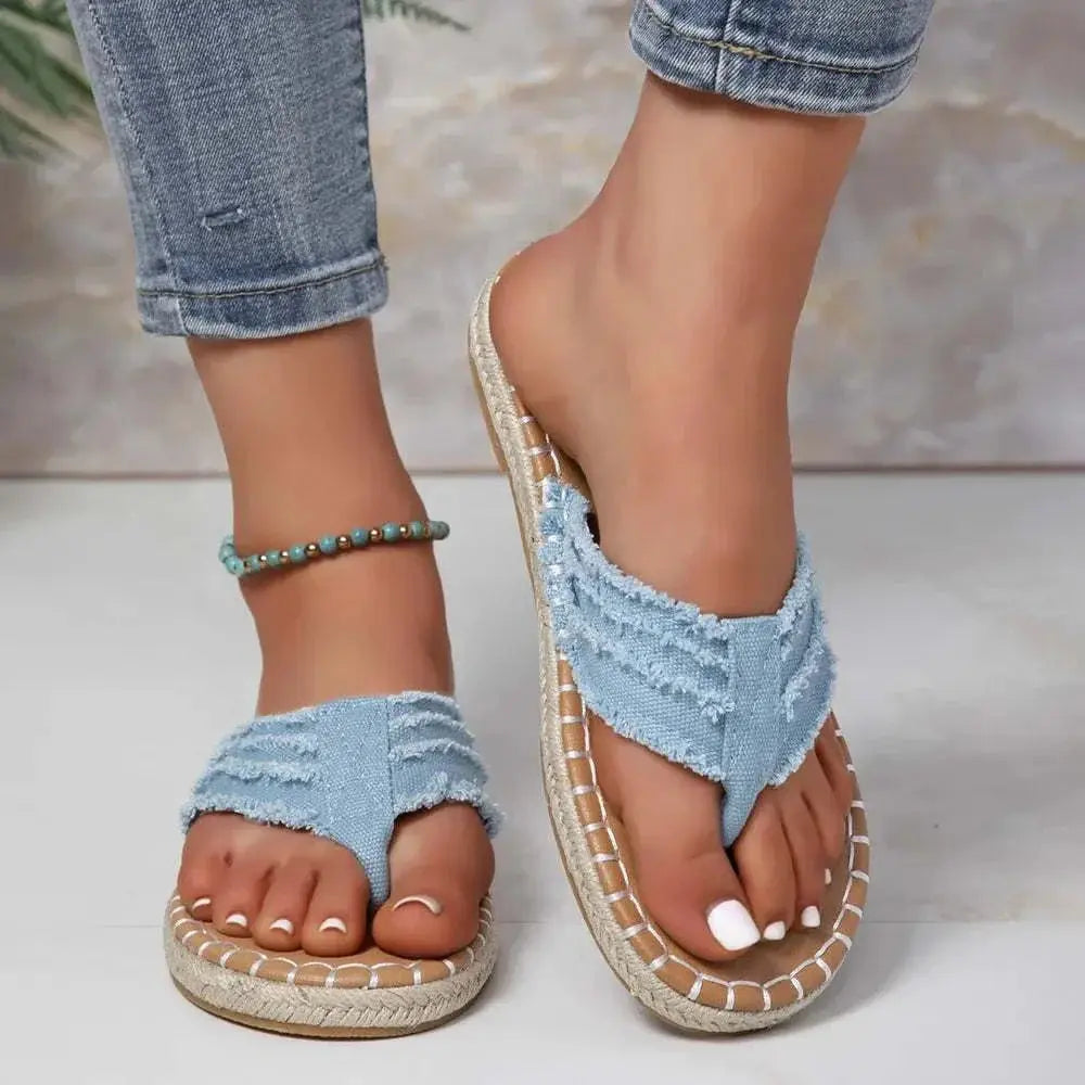 Toe post raw hem flat sandals in blue canvas with rubber sole.