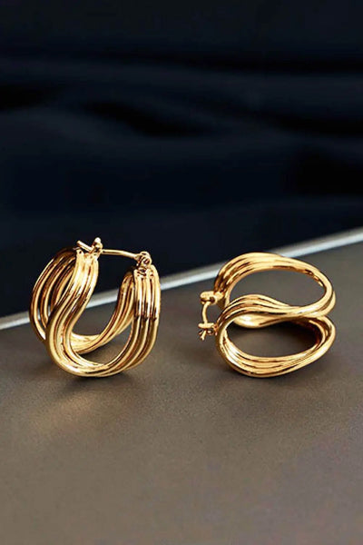 U-Shaped hoop earrings in brass, studio flat lay.