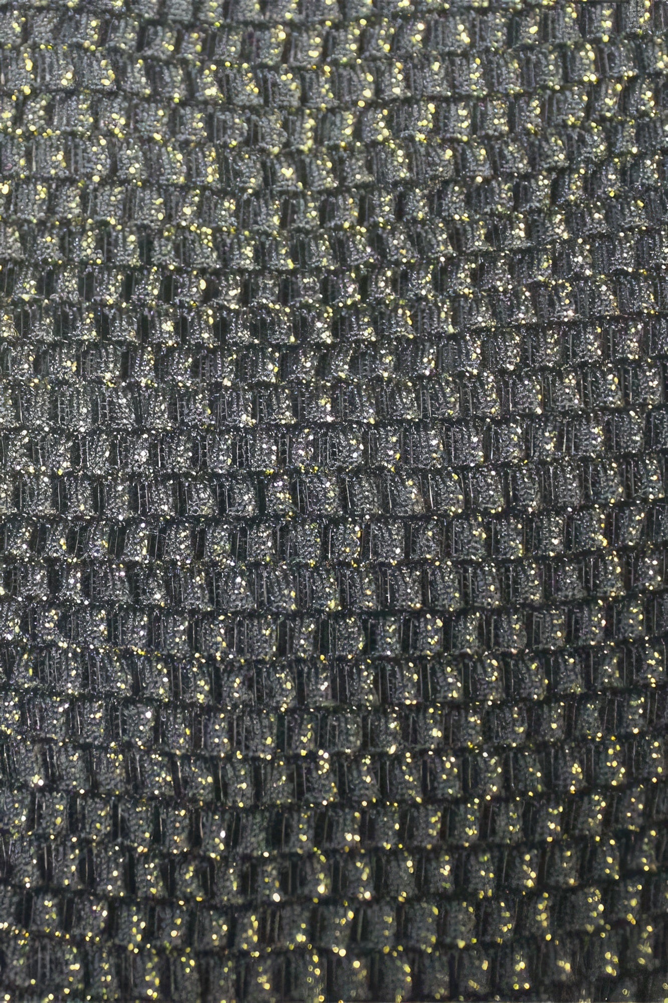 Close-up texture of black Crossback Bralette fabric with subtle golden accents.