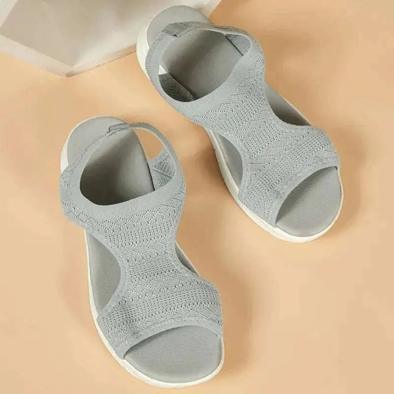 Peep toe solid color flat sandals in grey, rubber and cloth material.