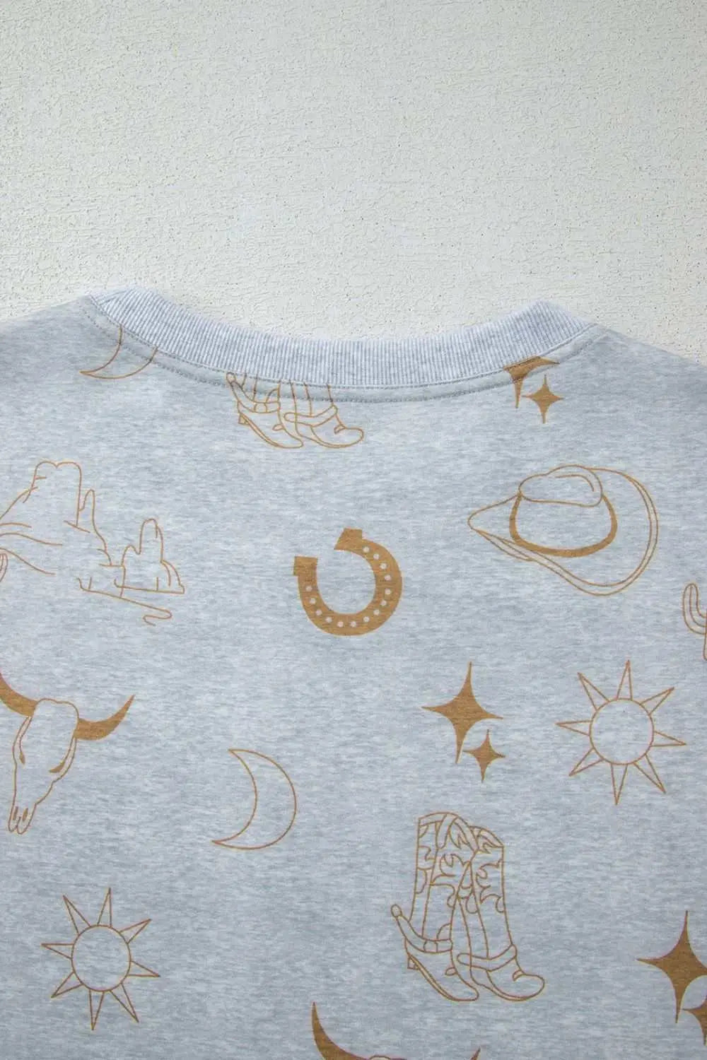 Printed T-shirt with western-themed graphics on a light gray fabric.