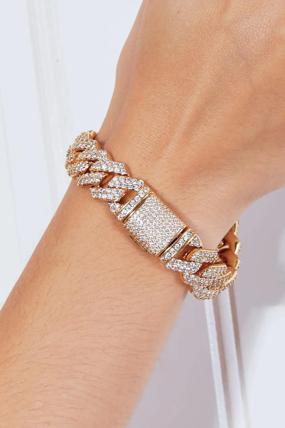 Alloy inlaid zircon bracelet with gold-plated chain on wrist.