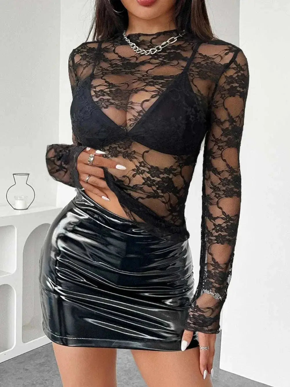 Mock neck sheer lace top, long sleeves, black, worn with black bralette and shiny skirt.