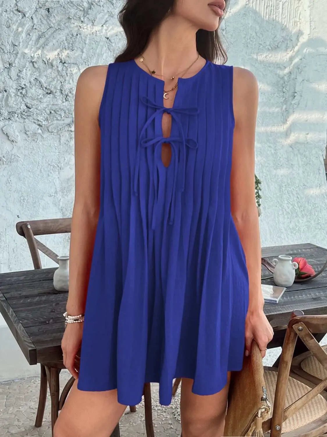 Devine Pleated Sleeveless Mini Dress in blue, featuring a tied neckline and pleated design.