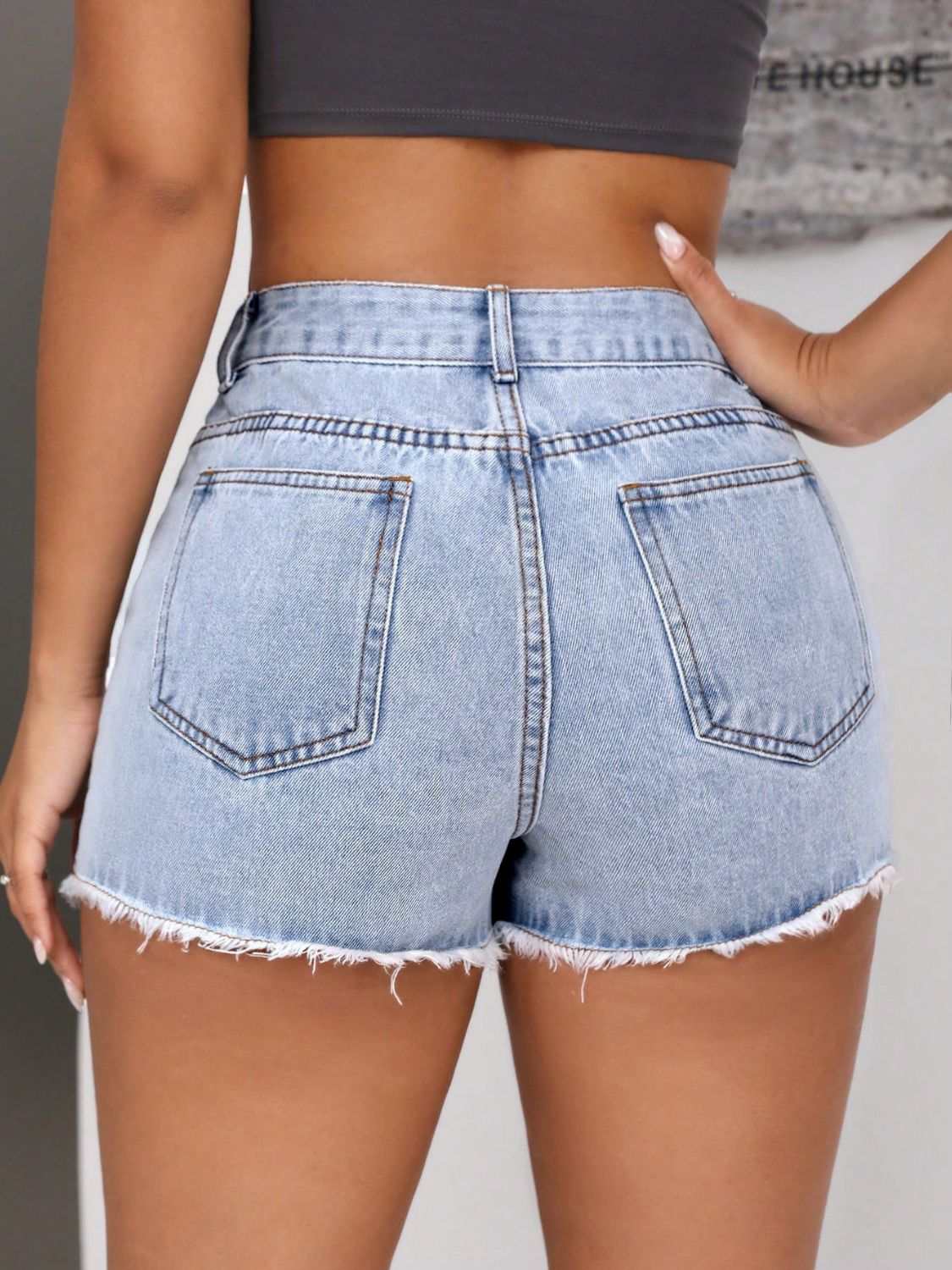 Raw hem pocketed denim shorts with fringe detail, featuring a buttoned design and no stretch.