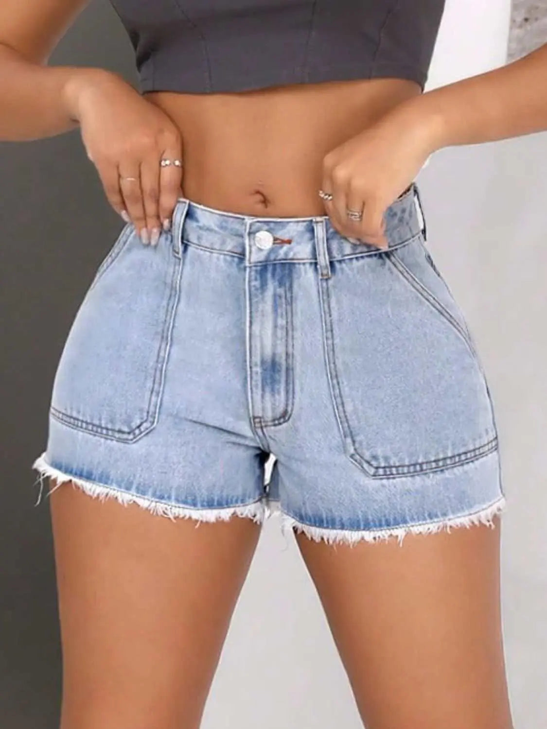 Raw hem pocketed denim shorts with button detail and fringe.