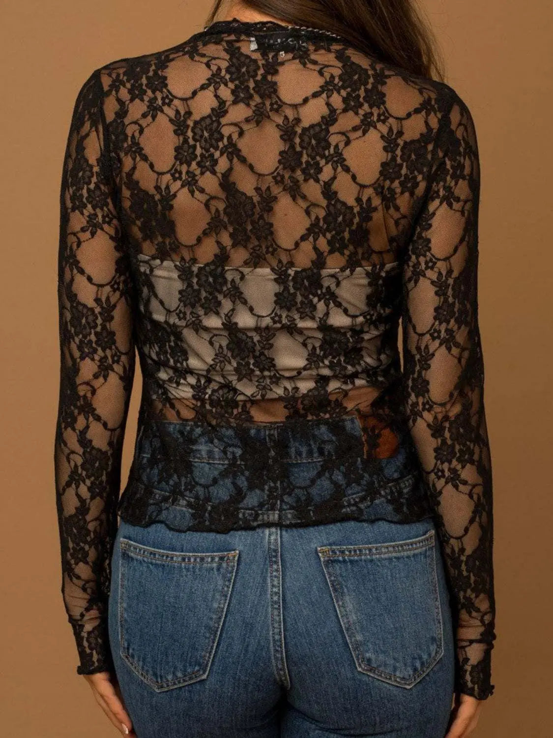 Sheer black lace mock neck long sleeve top with floral pattern.