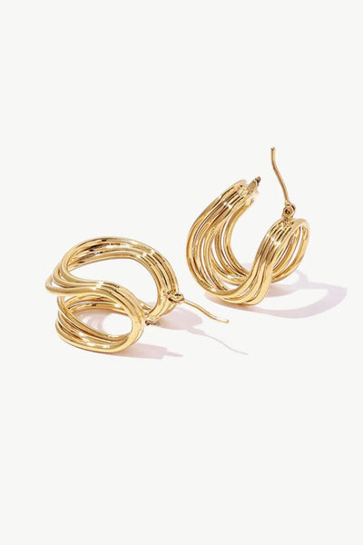 U-shaped brass hoop earrings in studio flat lay style.
